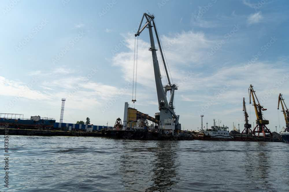 loading and unloading crane mounted on a small barge