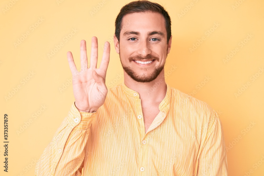 Young handsome man wearing casual clothes showing and pointing up with fingers number four while smiling confident and happy. Young handsome man wearing casual clothes showing and pointing up with fingers number four while smiling confident and happy.