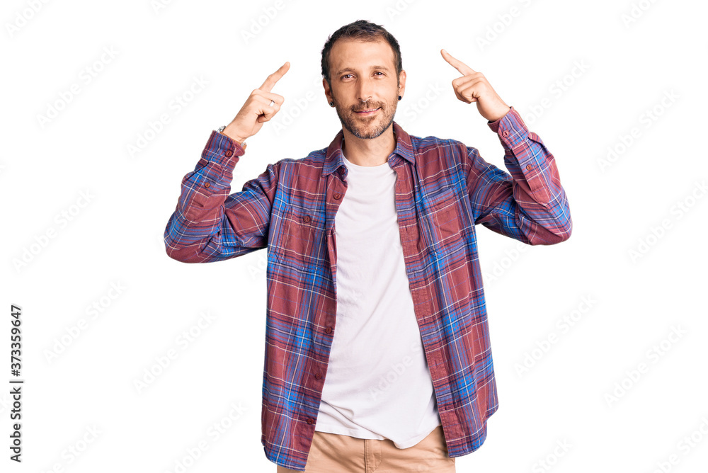 Young handsome man wearing casual clothes smiling pointing to head with both hands finger, great idea or thought, good memory Young handsome man wearing casual clothes smiling pointing to head with both hands finger, great idea or thought, good memory