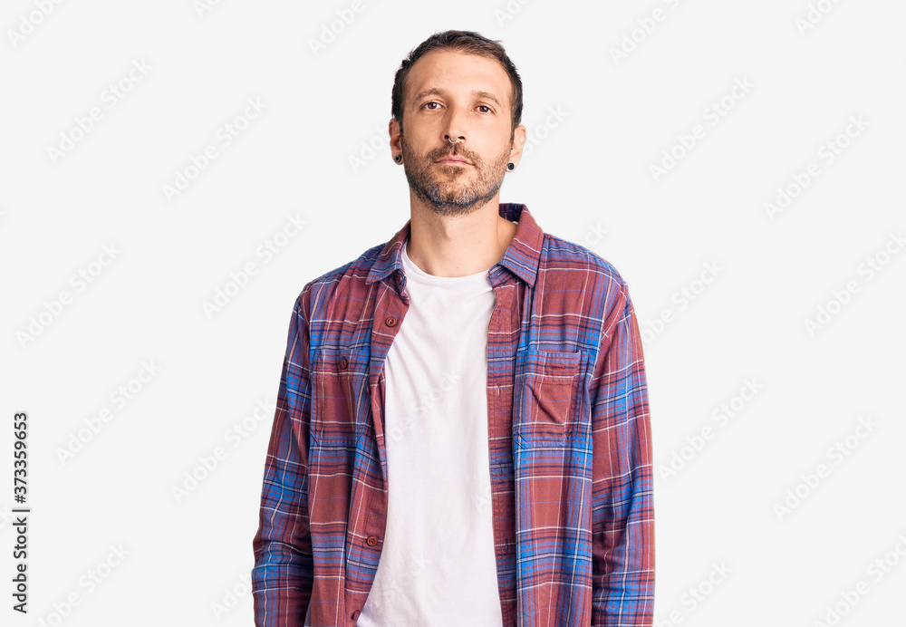 Young handsome man wearing casual clothes relaxed with serious expression on face. simple and natural looking at the camera. Young handsome man wearing casual clothes relaxed with serious expression on face. simple and natural looking at the camera.