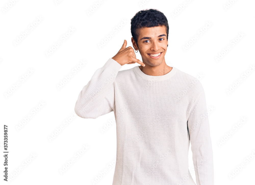 Young african amercian man wearing casual clothes smiling doing phone gesture with hand and fingers like talking on the telephone. communicating concepts. Young african amercian man wearing casual clothes smiling doing phone gesture with hand and fingers like talking on the telephone. communicating concepts.