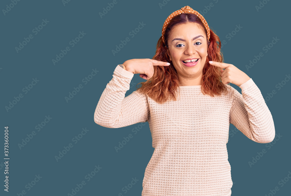 Fototapeta premium Young latin woman wearing casual clothes and diadem smiling cheerful showing and pointing with fingers teeth and mouth. dental health concept.