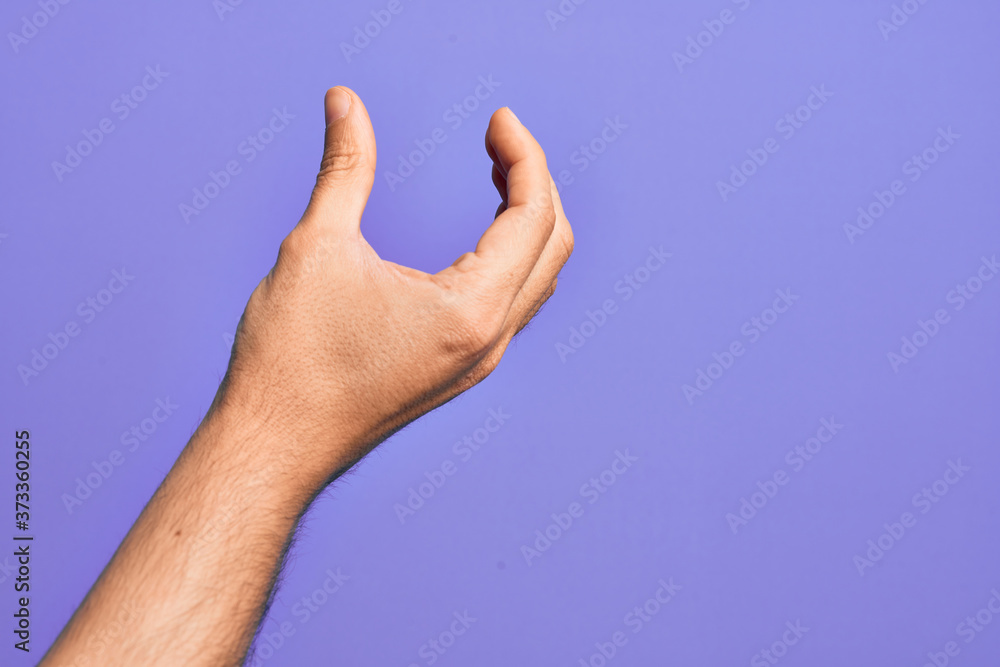 Hand of caucasian young man showing fingers over isolated purple background picking and taking invisible thing, holding object with fingers showing space Hand of caucasian young man showing fingers over isolated purple background picking and taking invisible thing, holding object with fingers showing space