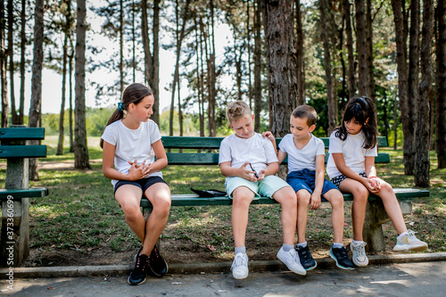 School boy with diabetes testing his blood sugar after physical education, friends support him.