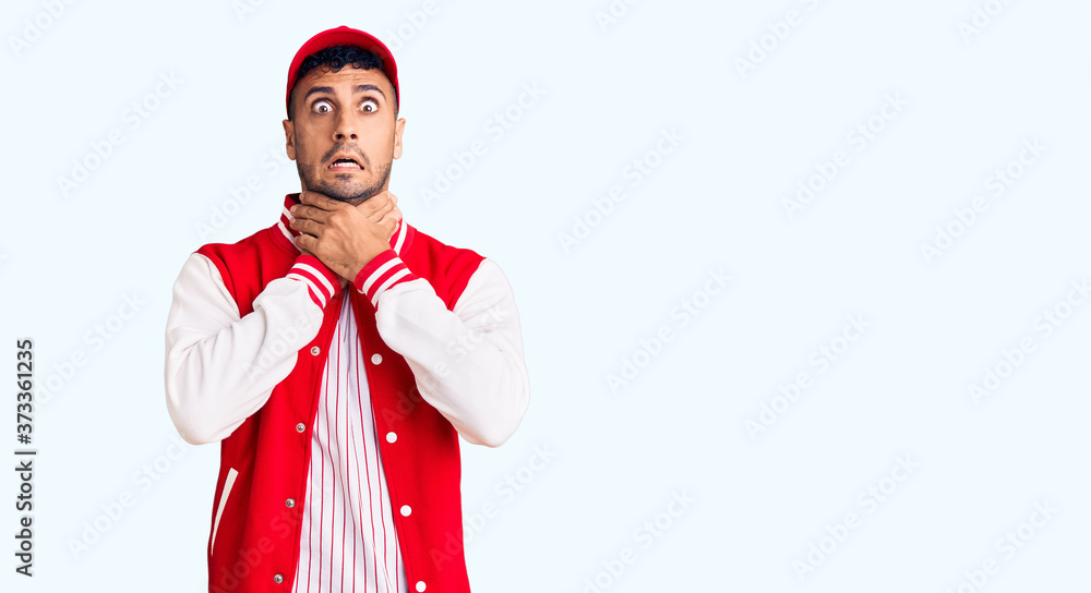 Young hispanic man wearing baseball uniform shouting and suffocate because painful strangle. health problem. asphyxiate and suicide concept. Young hispanic man wearing baseball uniform shouting and suffocate because painful strangle. health problem. asphyxiate and suicide concept.