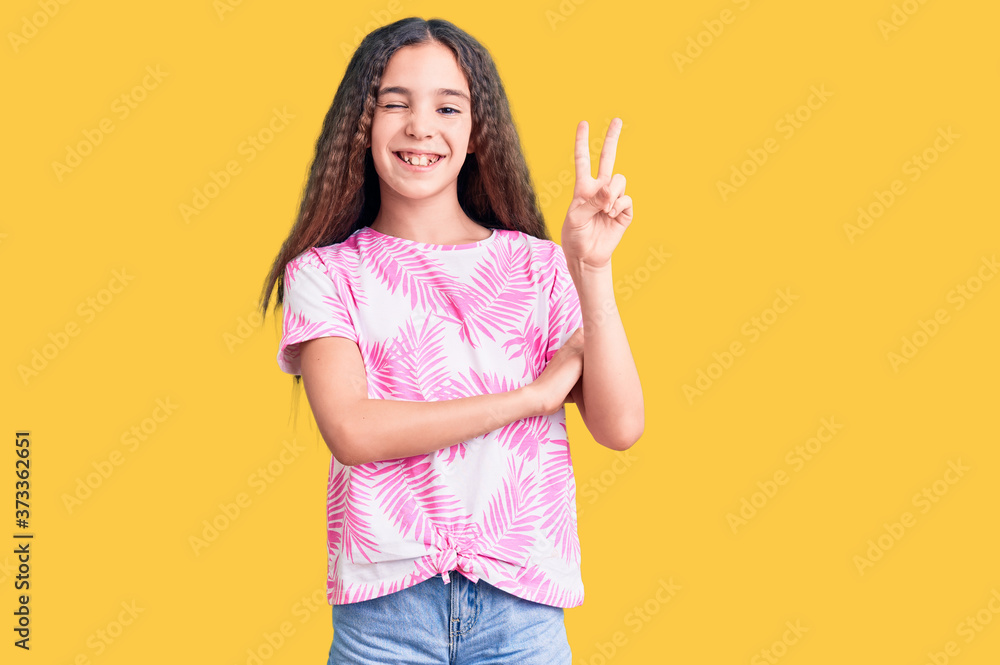 Cute hispanic child girl wearing casual clothes smiling with happy face winking at the camera doing victory sign. number two. Cute hispanic child girl wearing casual clothes smiling with happy face winking at the camera doing victory sign. number two.