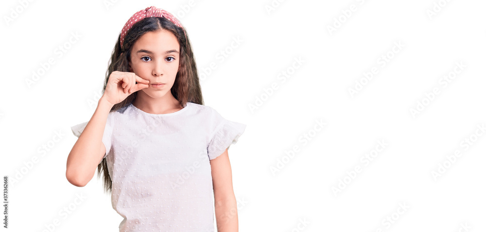 Cute hispanic child girl wearing casual white tshirt mouth and lips shut as zip with fingers. secret and silent, taboo talking Cute hispanic child girl wearing casual white tshirt mouth and lips shut as zip with fingers. secret and silent, taboo talking