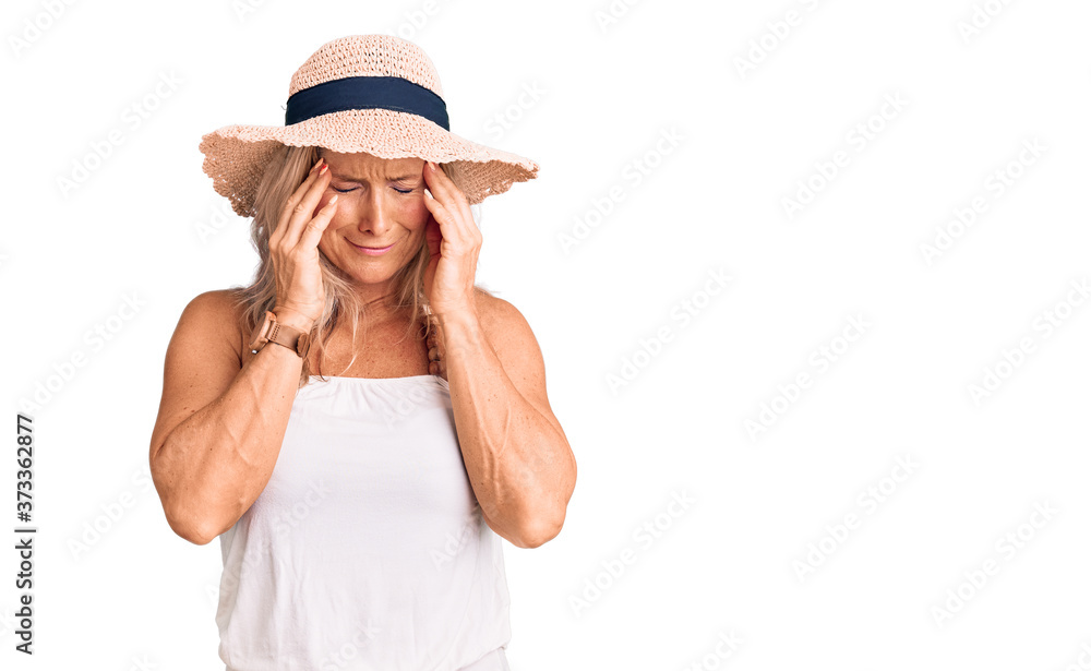 Middle age fit blonde woman wearing summer hat with hand on head for pain in head because stress. suffering migraine. Middle age fit blonde woman wearing summer hat with hand on head for pain in head because stress. suffering migraine.