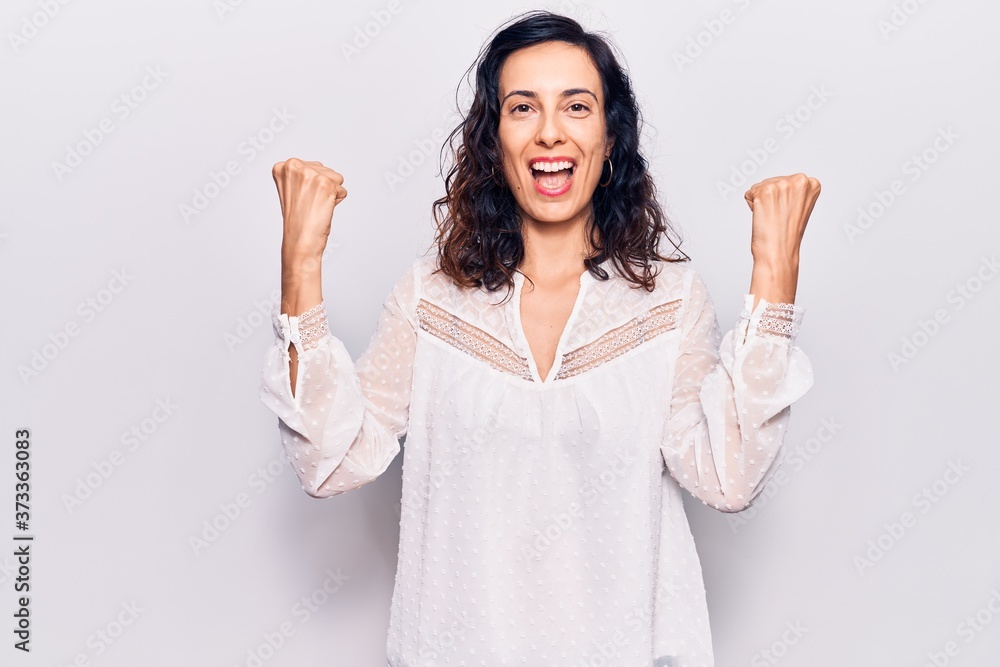 Young beautiful hispanic woman wearing casual clothes screaming proud, celebrating victory and success very excited with raised arms Young beautiful hispanic woman wearing casual clothes screaming proud, celebrating victory and success very excited with raised arms