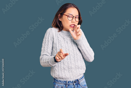 Young beautiful chinese girl wearing casual clothes disgusted expression, displeased and fearful doing disgust face because aversion reaction.