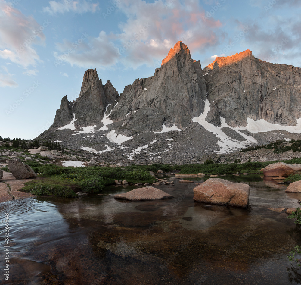 Warbonnet and warrior peak in the Wind River range of Wyoming reflect in water.