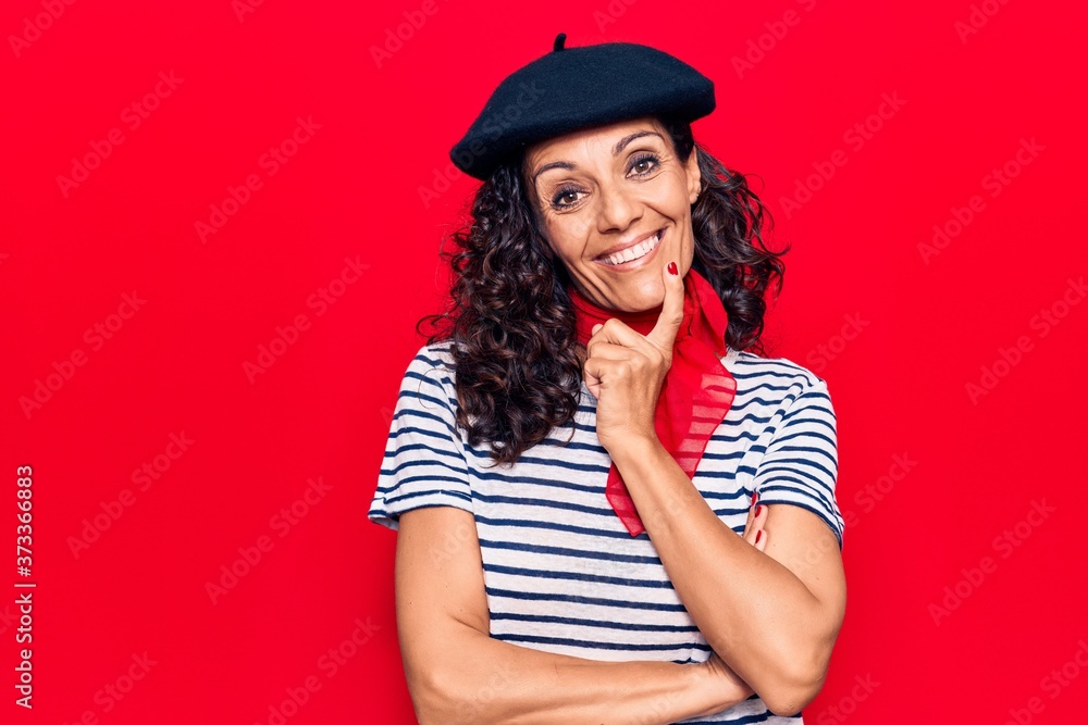 Middle age beautiful woman wearing french beret smiling looking confident at the camera with crossed arms and hand on chin. thinking positive. Middle age beautiful woman wearing french beret smiling looking confident at the camera with crossed arms and hand on chin. thinking positive.