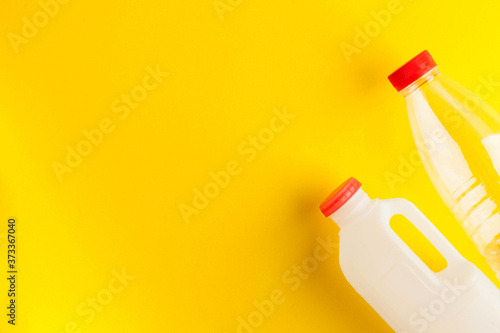 Unmarked biodegradable plastic milk bottles on a yellow background. Concept of dairy products. Zero waste. Copy space.