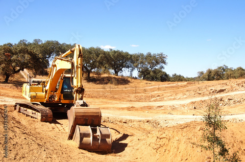 yellow excavator machine preparing soil of road construction