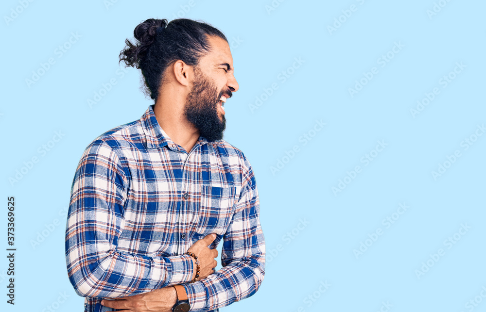 Young arab man wearing casual clothes with hand on stomach because nausea, painful disease feeling unwell. ache concept. Young arab man wearing casual clothes with hand on stomach because nausea, painful disease feeling unwell. ache concept.