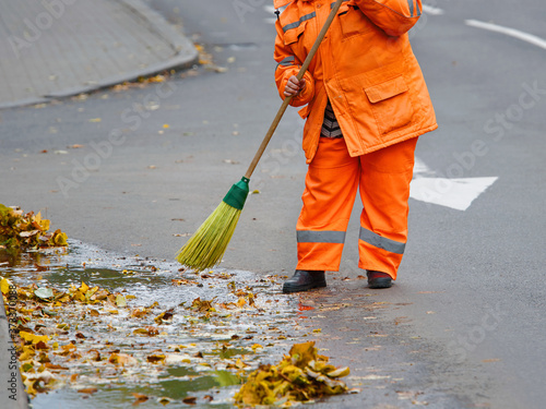 Obraz na plátně Worker cleaning street with broom tool
