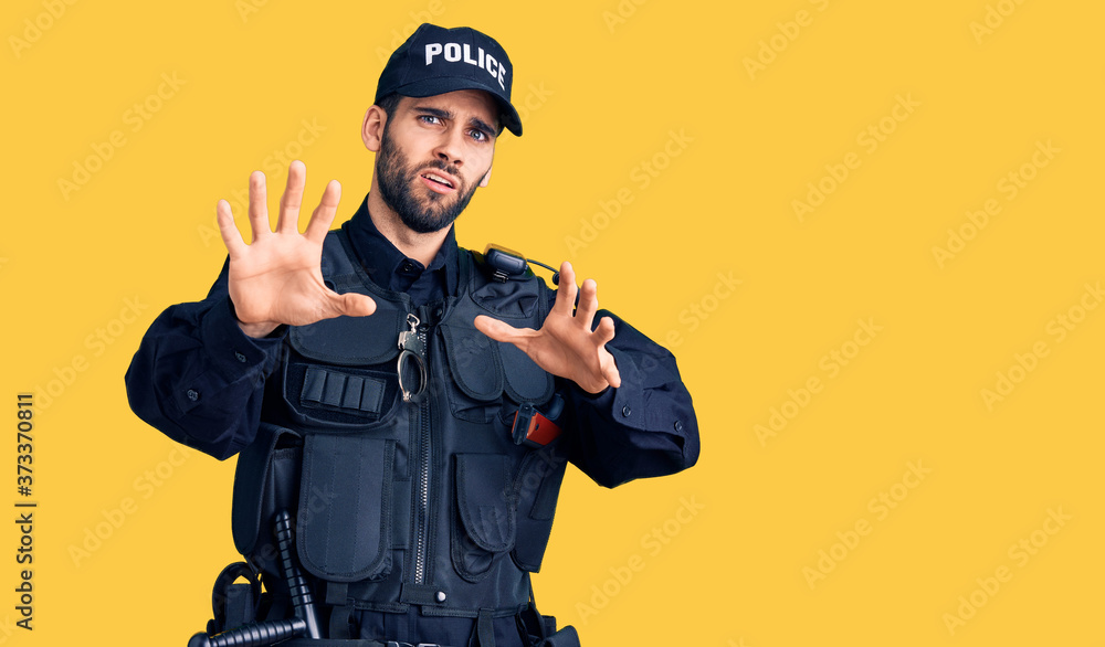 Young handsome man with beard wearing police uniform afraid and terrified with fear expression stop gesture with hands, shouting in shock. panic concept. Young handsome man with beard wearing police uniform afraid and terrified with fear expression stop gesture with hands, shouting in shock. panic concept.