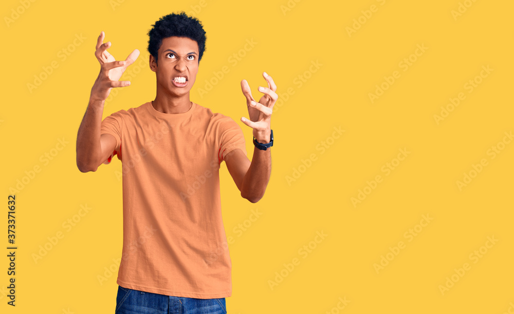 Young african american man wearing casual clothes shouting frustrated with rage, hands trying to strangle, yelling mad Young african american man wearing casual clothes shouting frustrated with rage, hands trying to strangle, yelling mad