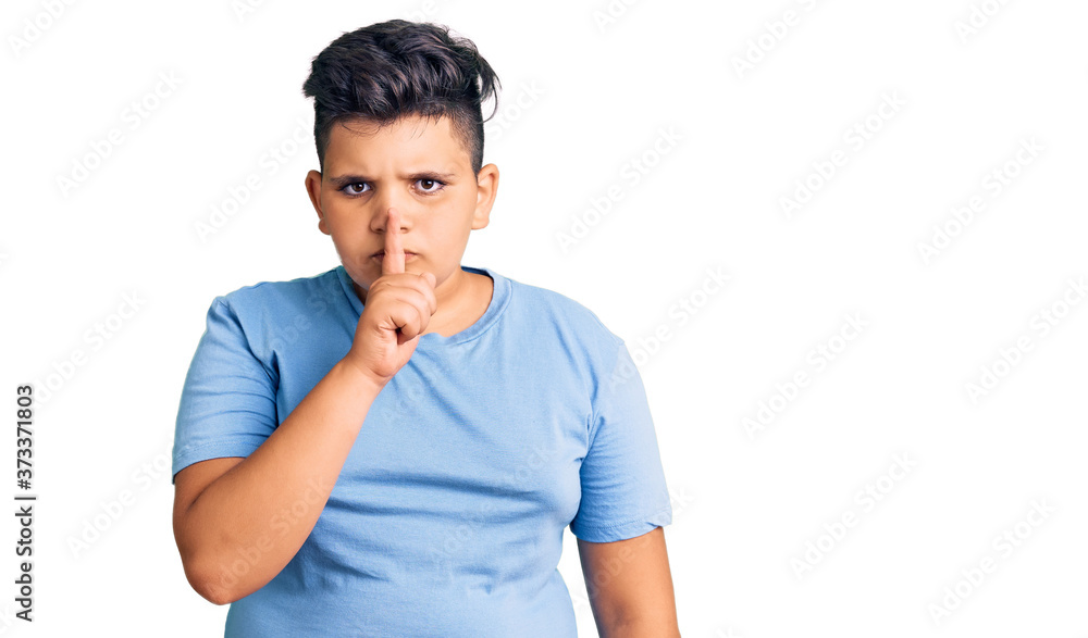 Little boy kid wearing sports workout clothes asking to be quiet with finger on lips. silence and secret concept. Little boy kid wearing sports workout clothes asking to be quiet with finger on lips. silence and secret concept.