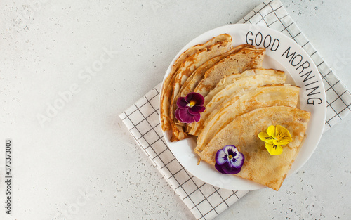 French crepes, pancakes decorated with flowers. Concept of Breakfast, dessert. Copy space. French culture, Maslenitsa photo