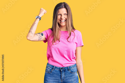Beautiful caucasian woman wearing casual clothes angry and mad raising fist frustrated and furious while shouting with anger. rage and aggressive concept.