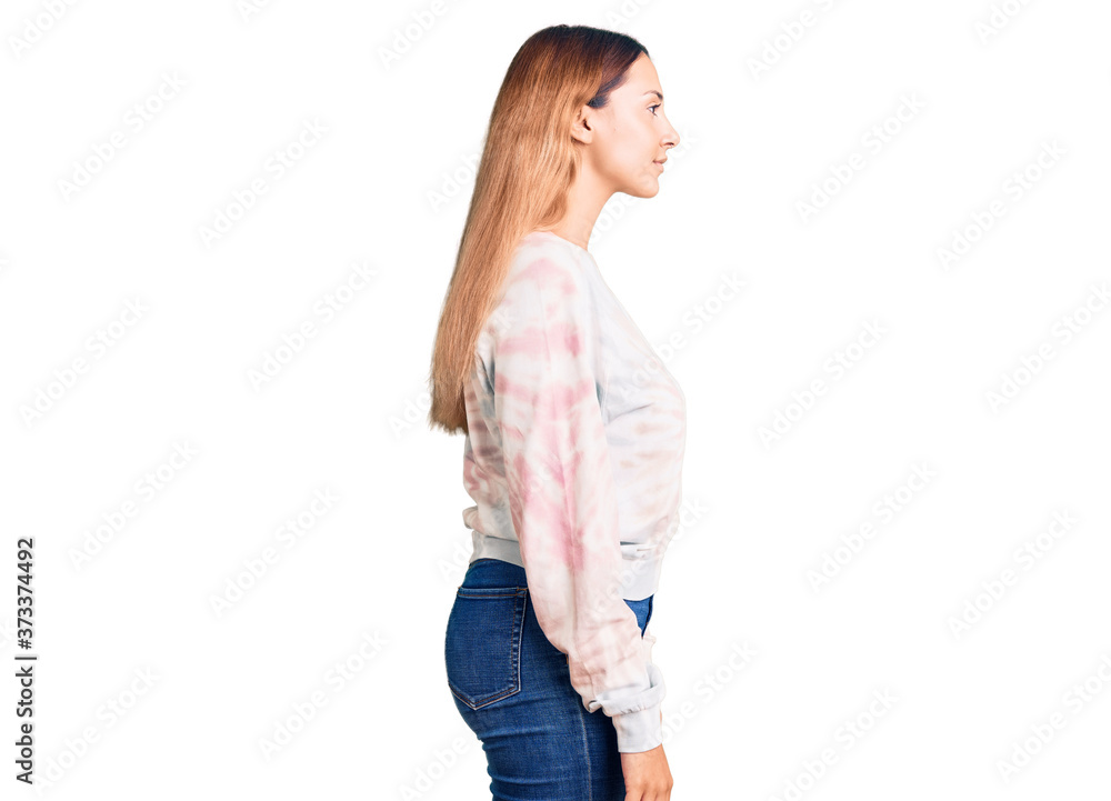 Beautiful young woman wearing casual tie dye sweatshirt looking to side, relax profile pose with natural face with confident smile. Beautiful young woman wearing casual tie dye sweatshirt looking to side, relax profile pose with natural face with confident smile.