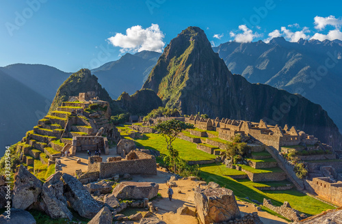The lost inca city of Machu Picchu with the last sun rays illuminating the most famous landscape of Peru, South America. photo