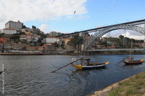Dom Luis I bridge and traditional boats with wine barrels on Rio Douro river in Porto  Portugal