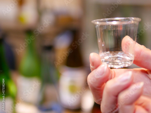 A plastic cup holding in a hand with blur background