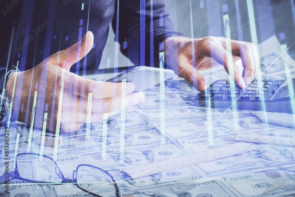 Double exposure of man's hands holding and using a digital device and forex graph drawing. Financial market concept. Double exposure of man's hands holding and using a digital device and forex graph drawing. Financial market concept.