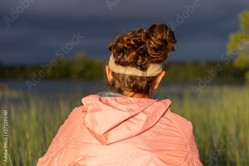 A woman takes a break from paddling through tall grass in Lake Umbagog to take in the scenery photo
