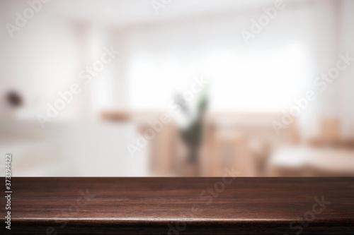 Empty wooden desk space and blurry background of cafe or Restaurant for product display montage. © qOppi