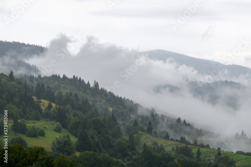 Majestic view on beautiful fog and cloud mountains in mist landscape. © byrdyak