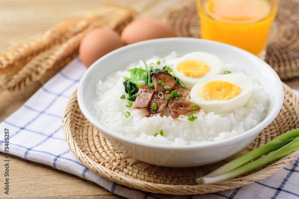Asian breakfast food, Rice soup with boiled egg, grilled mushroom and spinach in bowl Asian breakfast food, Rice soup with boiled egg, grilled mushroom and spinach in bowl