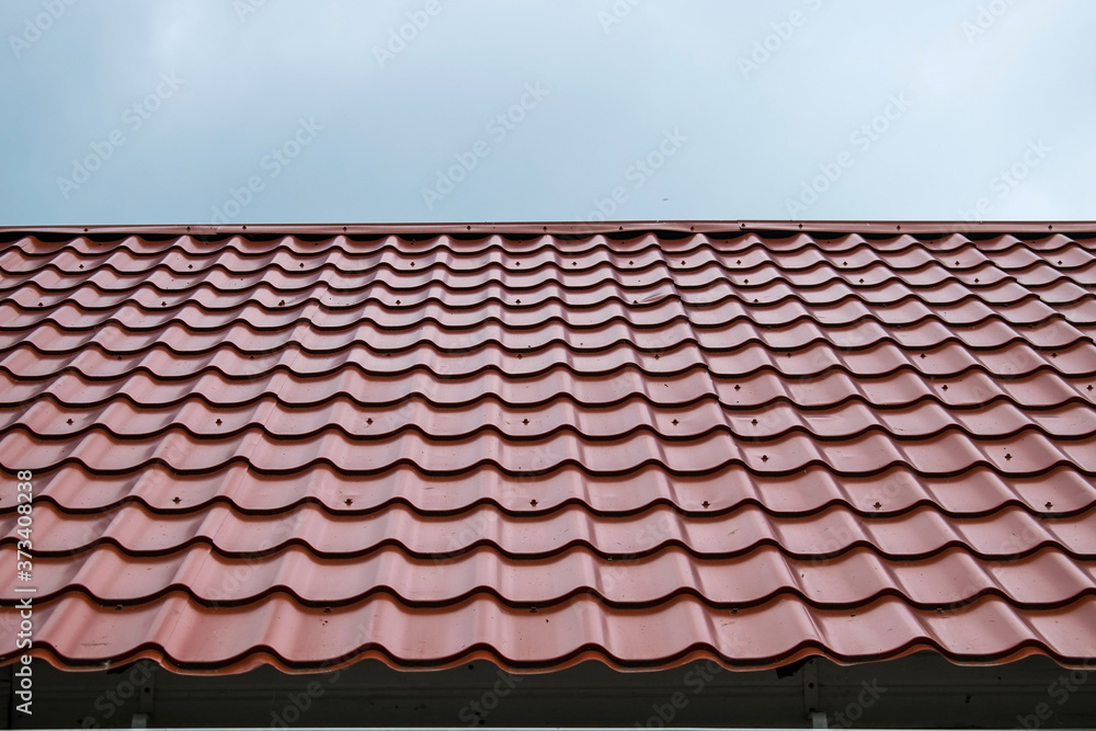 Tiled patterned red roof against a blue sky Tiled patterned red roof against a blue sky
