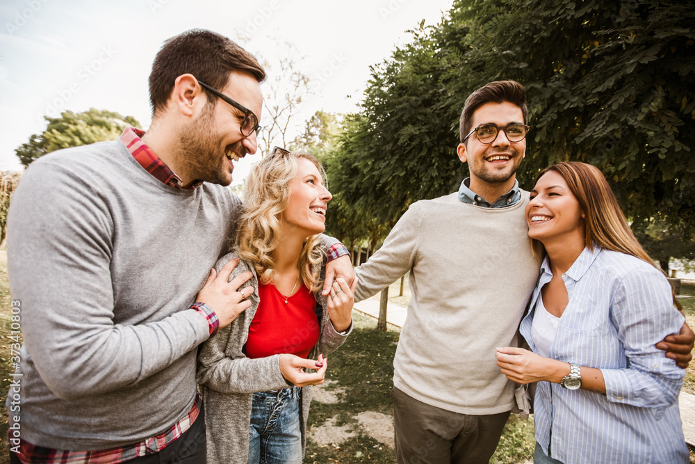 Group of young people walking through park. Friends having fun outdoor Group of young people walking through park. Friends having fun outdoor