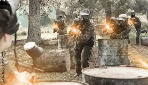 concentrated teams facing on battlefield in outdoor paintball arena during the match