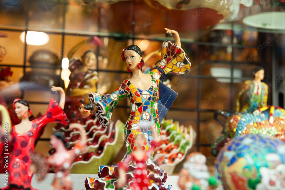 Variety of traditional mosaic figurines on shelves of souvenir shop in Barcelona