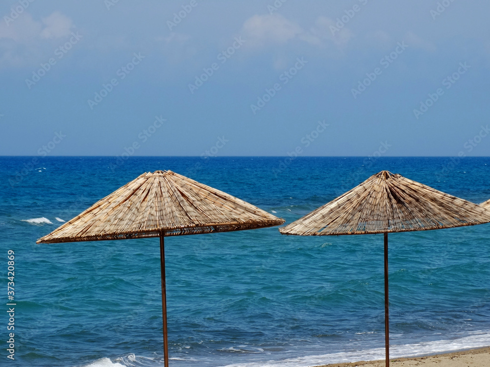 Natural landscape at seaside with sunbathing protection of umbrellas decoration. Seasonal seascape with sunlight background photos.