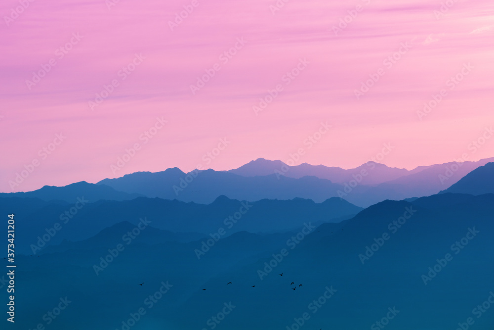 Obraz premium Silhouette of mountain ranges against the sunset sky