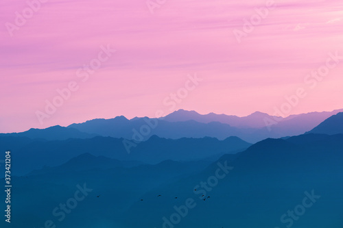 Silhouette of mountain ranges against the sunset sky