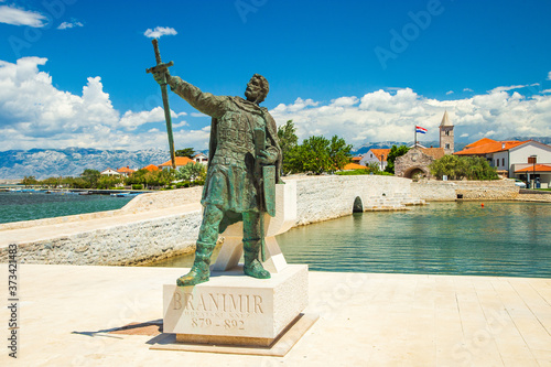 Photography Old stone bridge and city gates with monument of medieval Croatian duke in the t