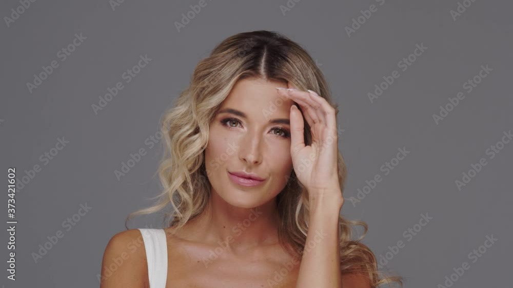 Studio portrait of young and beautiful blond woman over grey background. Studio portrait of young and beautiful blond woman over grey background.