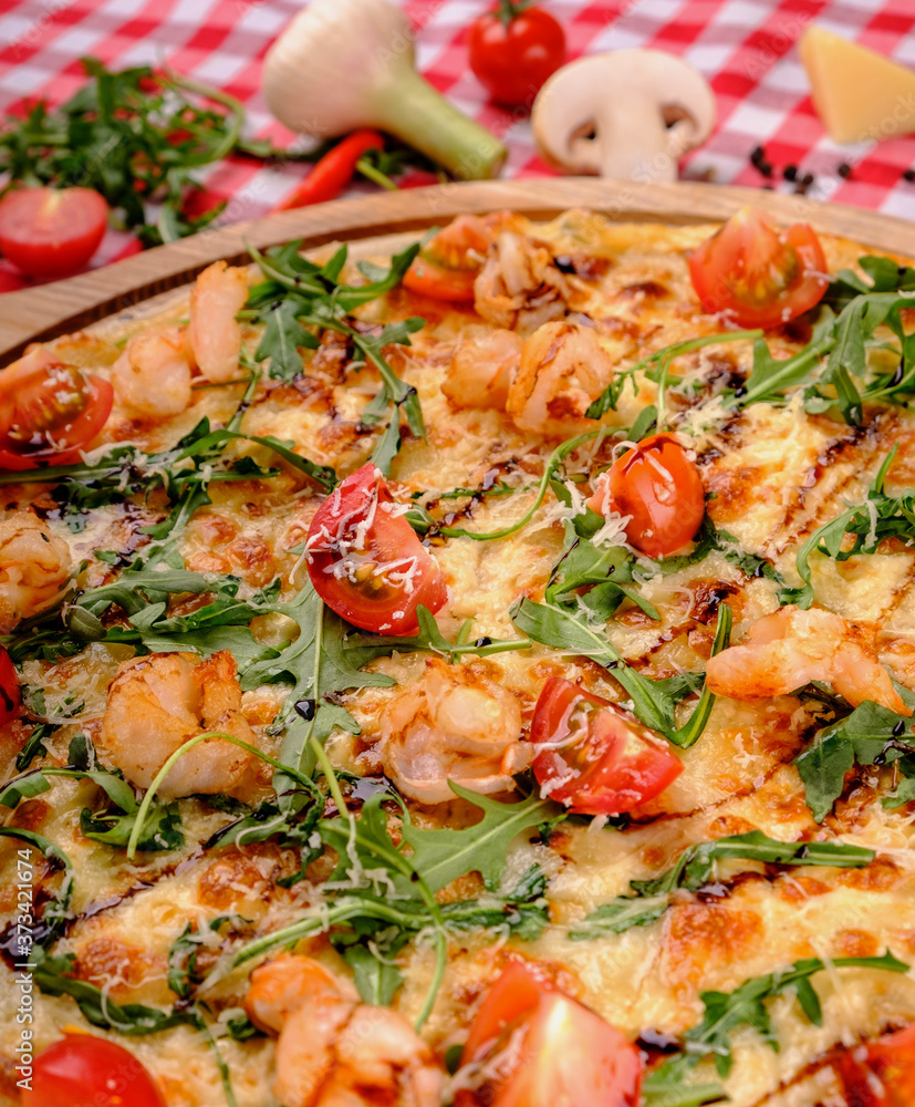 Pizza with seafood, mozzarella, mussels, octopus, squid, salmon, shrimp, cheeseand, fresh rucola and tomatoes sauce in italian restaurant background, top view. Mediterranean food. Pizza with seafood, mozzarella, mussels, octopus, squid, salmon, shrimp, cheeseand, fresh rucola and tomatoes sauce in italian restaurant background, top view. Mediterranean food.