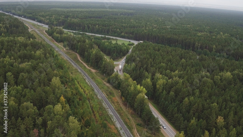 Sky view of summer road with cars and trucks. Summer forest and highway road drone view. Highway truck traffic