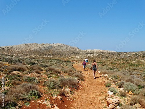 Tourists visit Balos in Crete, Greece and hiking toward to the beach. The Gramvousa Peninsula forms the westernmost of the two pairs of peninsula in Crete and the western part of Kissamos Bay.