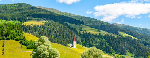 Rural church in green hilly landscape of Dolomites, Winnebach village, Italy photo