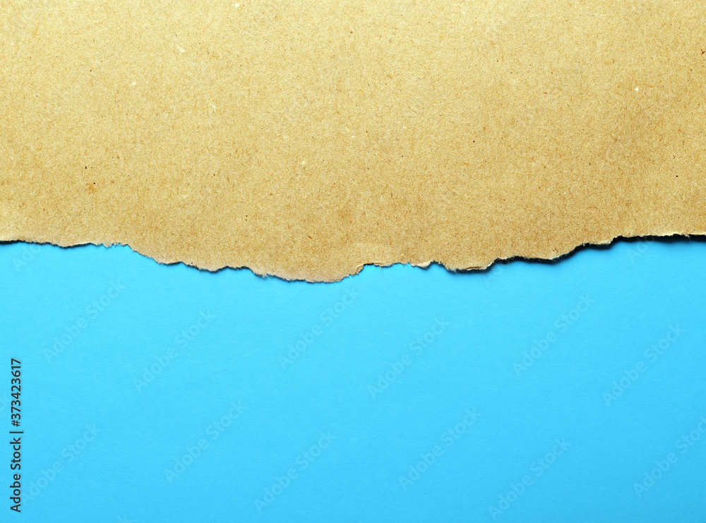 Wrapped paper with torn edges isolated with a bright blue background paper inside. Nice paper texture Place for text.