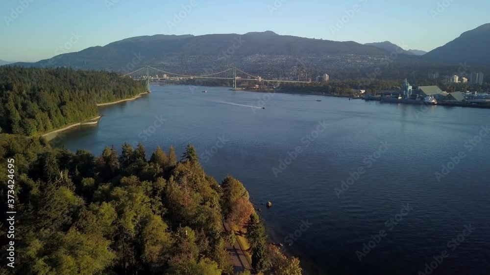 Lions Gate Bridge Over Burrard Inlet With Sailing Boats From Stanley Park In Vancouver, Canada. - aerial drone Lions Gate Bridge Over Burrard Inlet With Sailing Boats From Stanley Park In Vancouver, Canada. - aerial drone