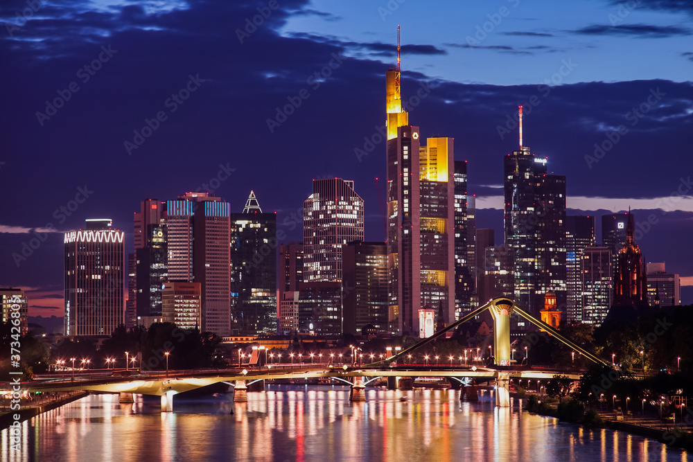 The illuminated skyline of Frankfurt am Main, Germany during the night with skyscrapers